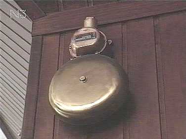 ONE OF THE SHIPS ALARM BELLS ARE ON SHOW IN THE CAFE.